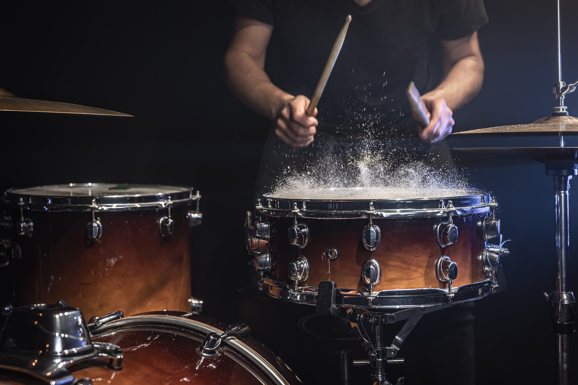 The drummer plays the snare drum with splashing water.